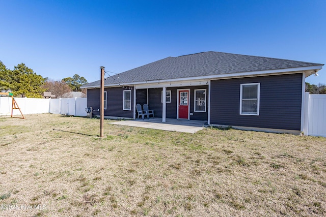 back of house featuring a patio area, a fenced backyard, roof with shingles, and a yard