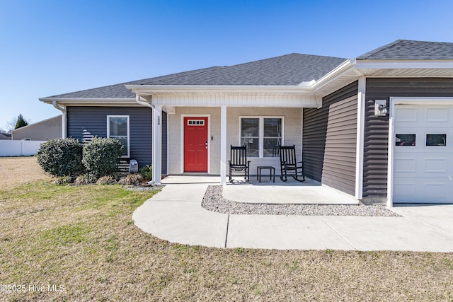 view of front of property featuring an attached garage, a shingled roof, a porch, and a front yard