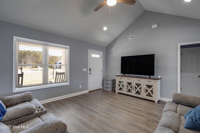 living room featuring visible vents, baseboards, and wood finished floors