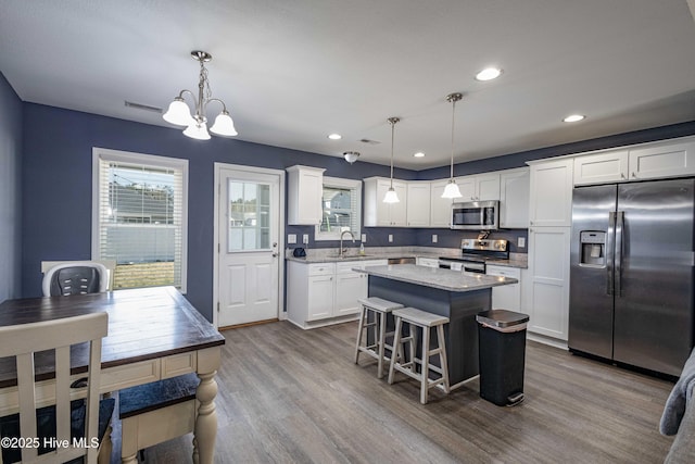 kitchen featuring appliances with stainless steel finishes, a center island, white cabinetry, and dark wood-style floors