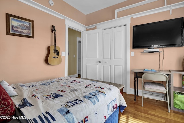 bedroom featuring wood finished floors, a closet, and baseboards