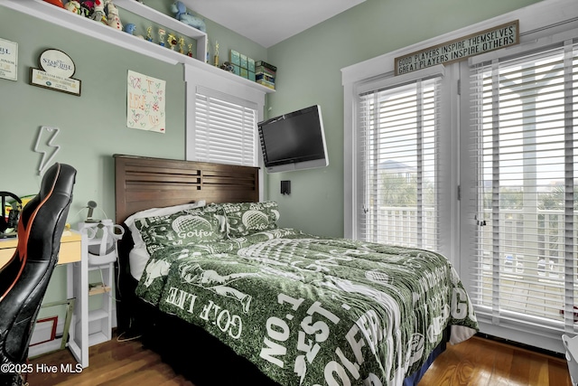 bedroom featuring wood finished floors and access to exterior