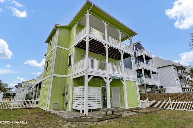 back of property featuring board and batten siding and fence