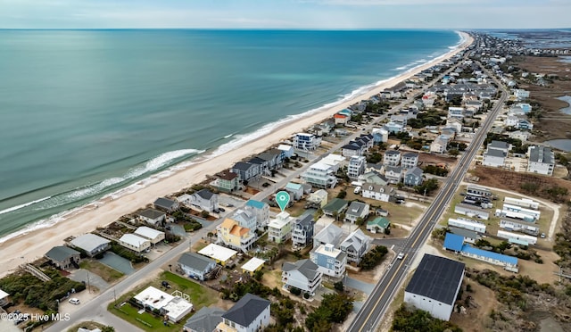 birds eye view of property with a water view and a beach view