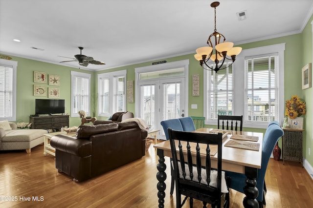 dining room with wood finished floors, visible vents, and ornamental molding