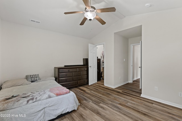 4000 W T Whitehead Dr, Jacksonville, NC 28546 - bedroom with vaulted ceiling, wood finished floors, a ceiling fan, and a walk in closet