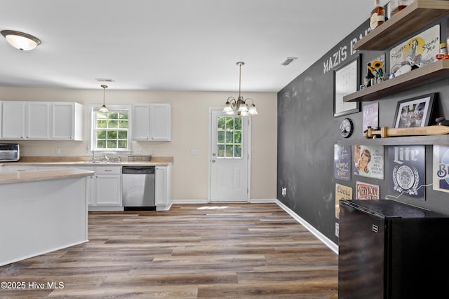 4000 W T Whitehead Dr, Jacksonville, NC 28546 - kitchen featuring stainless steel dishwasher, white cabinets, wood finished floors, light countertops, and pendant lighting