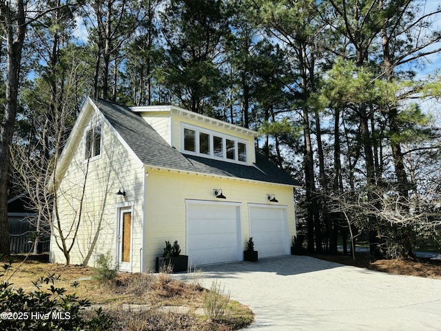 view of home's exterior featuring a garage, roof with shingles, and driveway