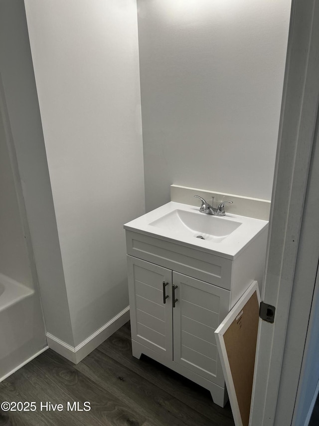 bathroom featuring wood finished floors, vanity, and baseboards