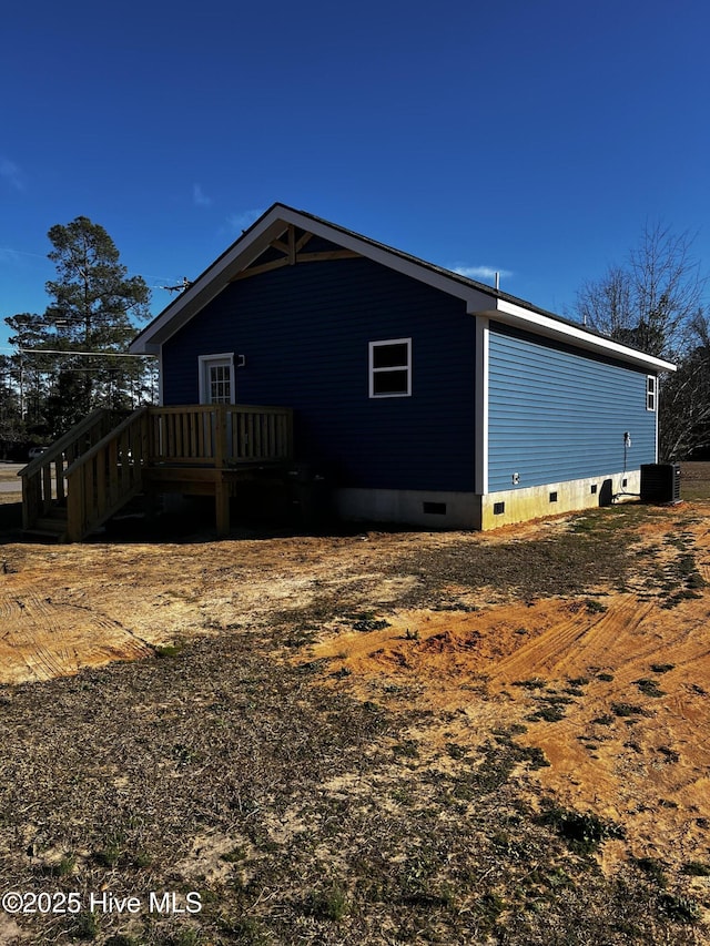 view of side of property with a deck, crawl space, and central air condition unit