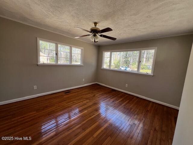 unfurnished room with crown molding, a textured ceiling, baseboards, and dark wood-style flooring