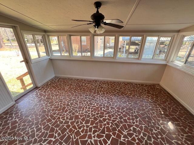 unfurnished sunroom with lofted ceiling and a ceiling fan