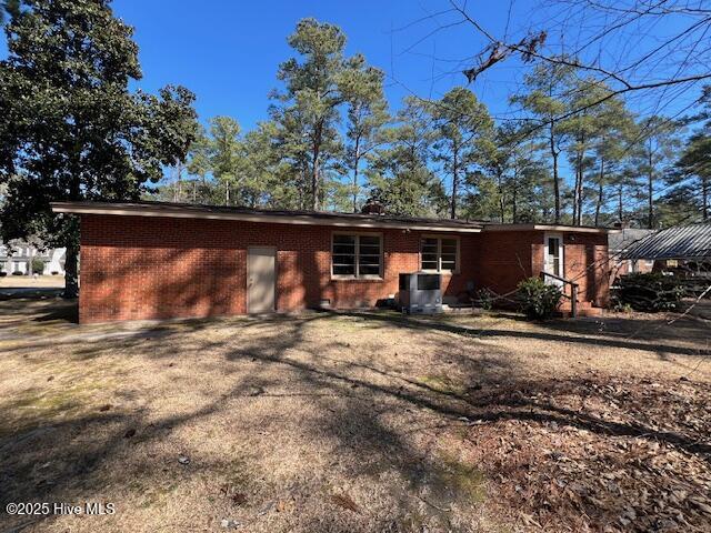 rear view of house with brick siding and central air condition unit