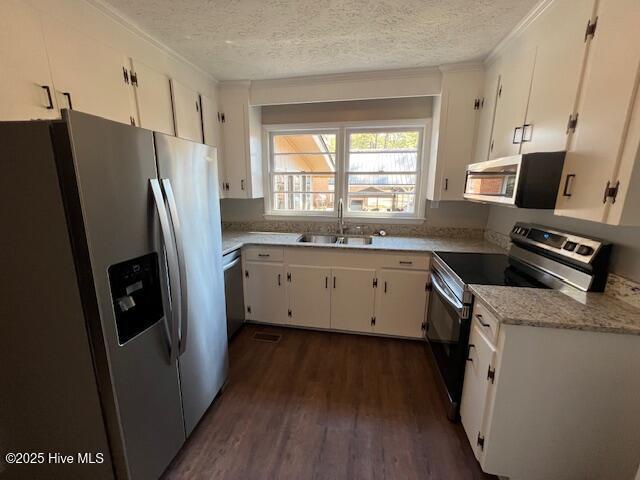 kitchen featuring stainless steel appliances, a sink, dark wood finished floors, and white cabinets