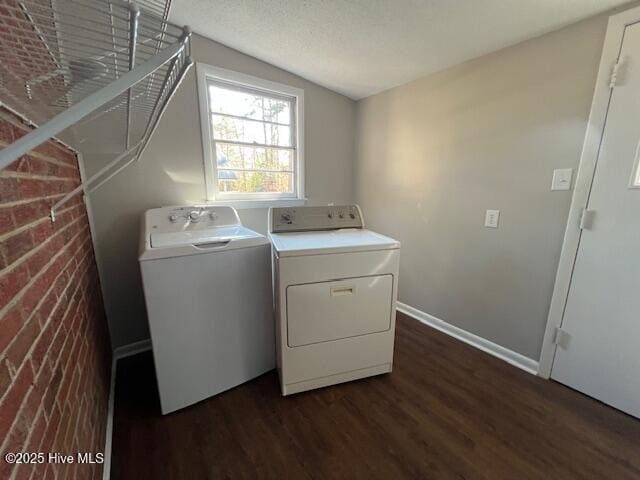 clothes washing area with a textured ceiling, laundry area, separate washer and dryer, baseboards, and dark wood-style floors