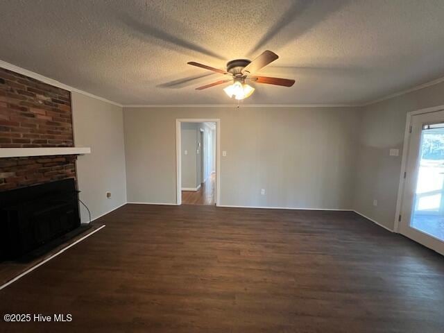 unfurnished living room featuring ceiling fan, ornamental molding, wood finished floors, a textured ceiling, and a brick fireplace