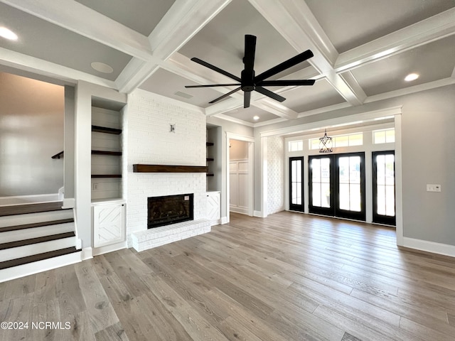 unfurnished living room with stairs, coffered ceiling, and wood finished floors