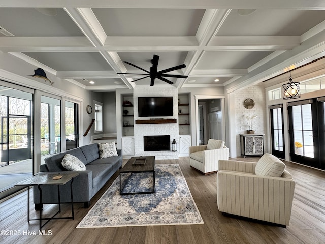 living area with dark wood-style floors, a fireplace, coffered ceiling, and beam ceiling