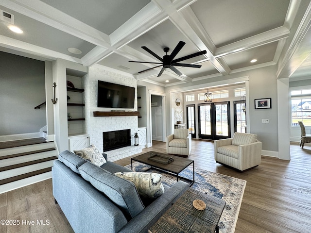 living room featuring beam ceiling, coffered ceiling, and wood finished floors