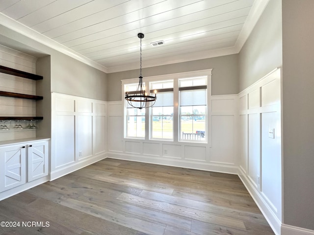 unfurnished dining area featuring crown molding, dark wood-style flooring, wooden ceiling, and a decorative wall