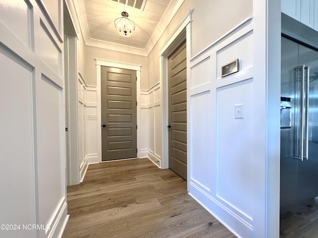 hallway featuring visible vents, elevator, wood ceiling, wood finished floors, and a decorative wall