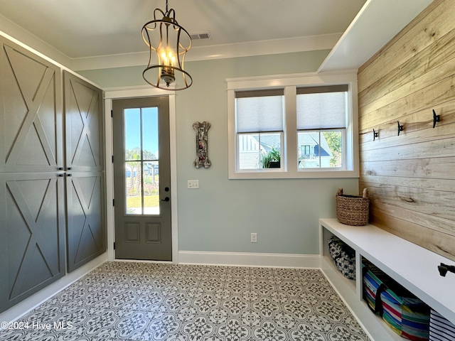 mudroom with a chandelier, plenty of natural light, baseboards, and tile patterned floors