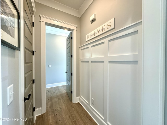 corridor featuring baseboards, dark wood-type flooring, and a decorative wall