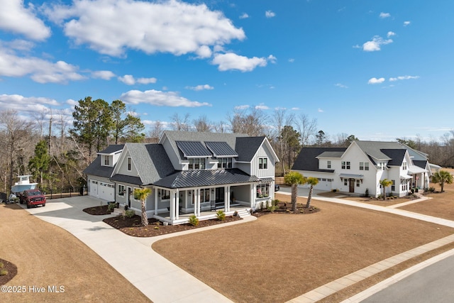 modern farmhouse style home with a porch, solar panels, driveway, a residential view, and a standing seam roof