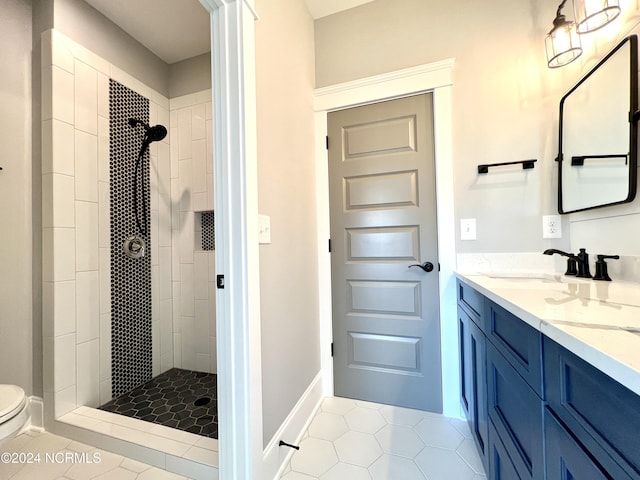 bathroom featuring baseboards, tiled shower, toilet, tile patterned floors, and vanity