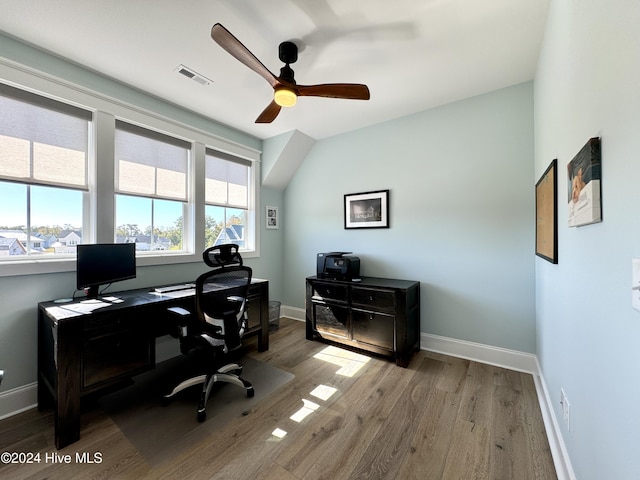 office space featuring a ceiling fan, visible vents, baseboards, and wood finished floors