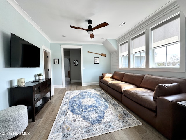 living room with a ceiling fan, visible vents, baseboards, ornamental molding, and light wood finished floors