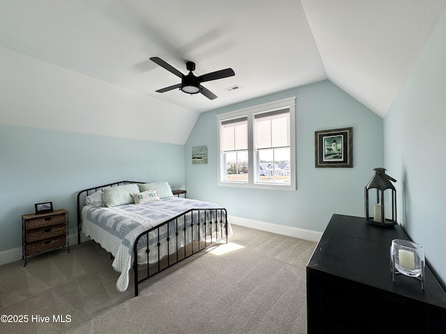 carpeted bedroom with lofted ceiling, visible vents, baseboards, and a ceiling fan