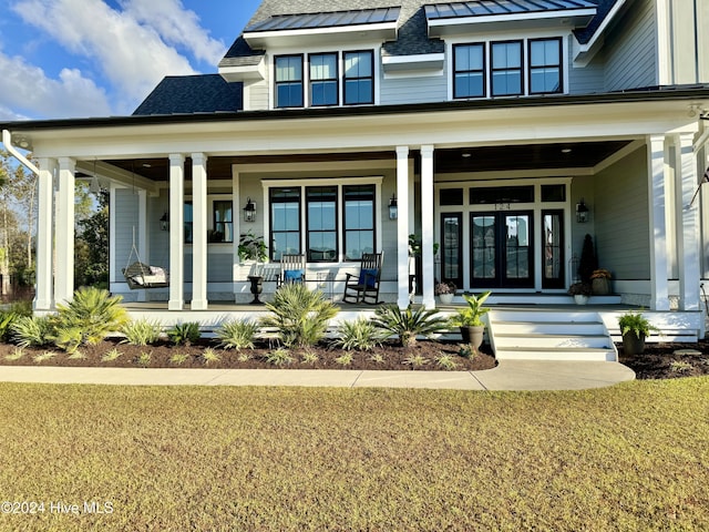 exterior space featuring a standing seam roof, a shingled roof, metal roof, and a porch