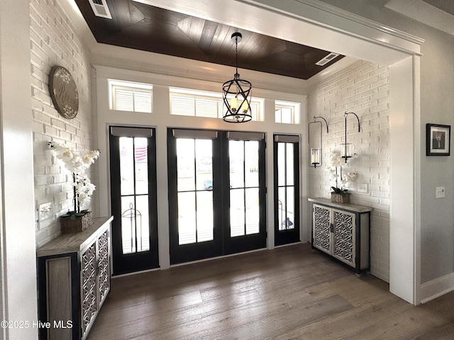 foyer entrance with brick wall, visible vents, hardwood / wood-style floors, and french doors