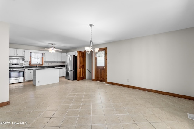 kitchen with appliances with stainless steel finishes, dark countertops, plenty of natural light, and backsplash