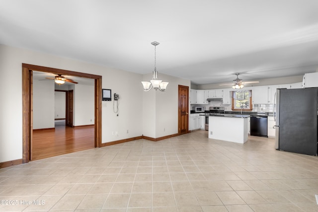 kitchen featuring dark countertops, stainless steel appliances, under cabinet range hood, white cabinetry, and light tile patterned flooring