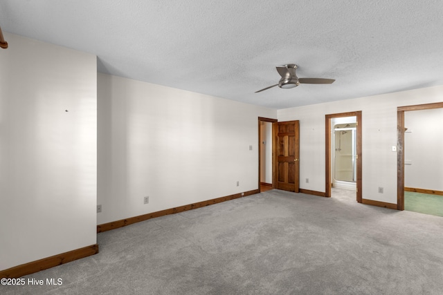 unfurnished bedroom with a textured ceiling, baseboards, carpet flooring, and ensuite bathroom