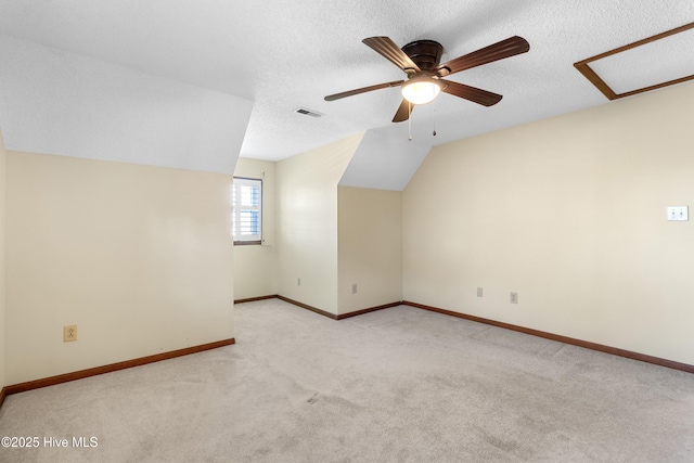 bonus room with carpet, lofted ceiling, visible vents, a textured ceiling, and baseboards