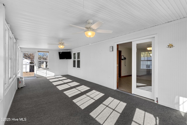 unfurnished sunroom with ceiling fan