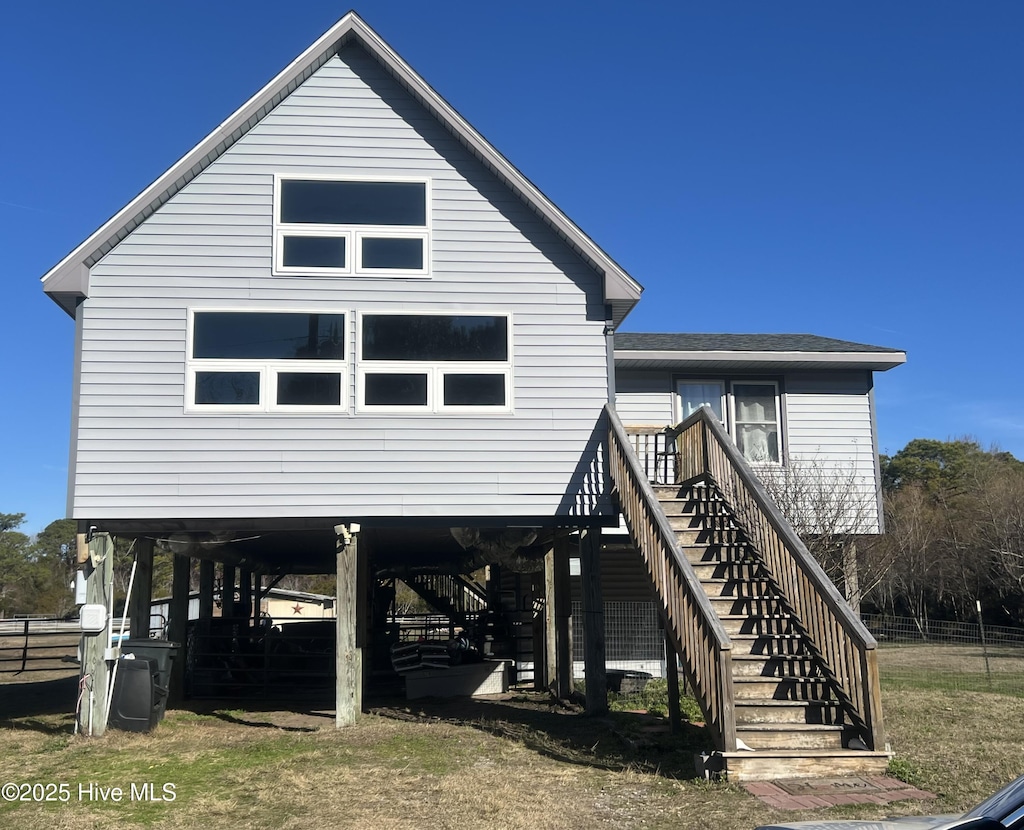 back of property featuring stairway and a carport