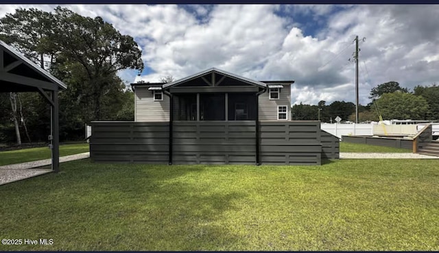 view of front facade featuring a sunroom, fence, and a front yard