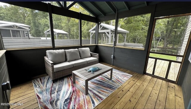 unfurnished sunroom featuring lofted ceiling with beams and plenty of natural light