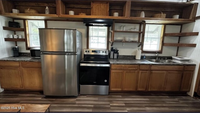 kitchen featuring a sink, appliances with stainless steel finishes, open shelves, dark countertops, and dark wood finished floors