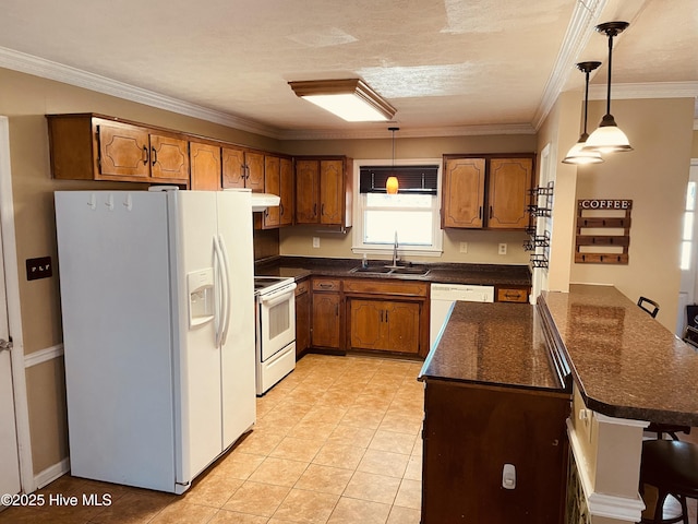 kitchen featuring white appliances, brown cabinetry, and a sink