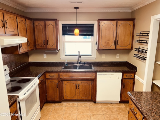 kitchen featuring white appliances, brown cabinetry, ornamental molding, under cabinet range hood, and a sink