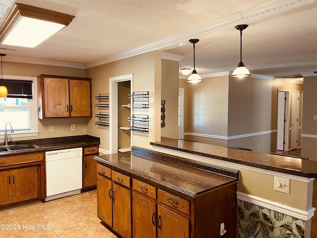 kitchen featuring brown cabinetry, a kitchen island, decorative light fixtures, white dishwasher, and a sink