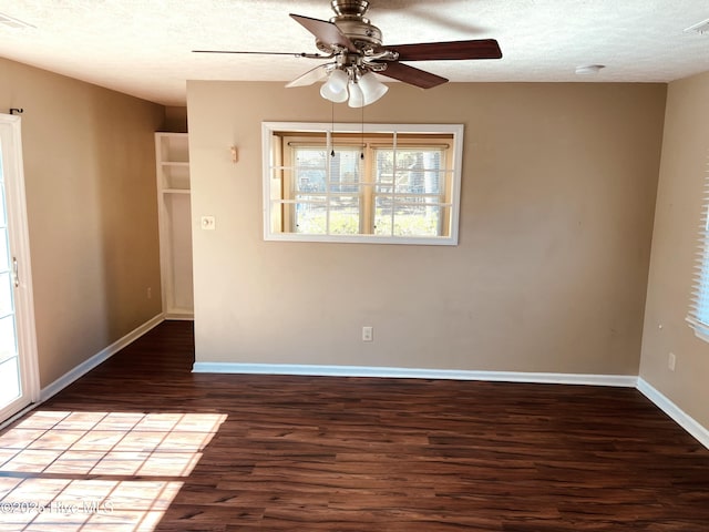 empty room featuring a textured ceiling, wood finished floors, visible vents, a ceiling fan, and baseboards