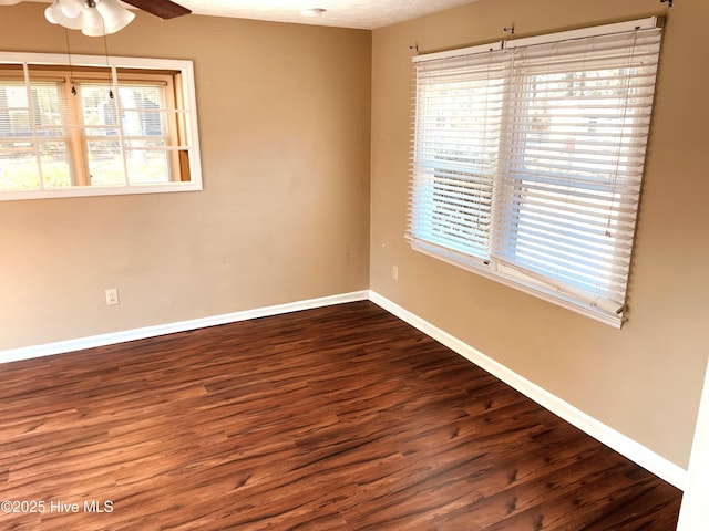 unfurnished room with a ceiling fan, baseboards, and wood finished floors