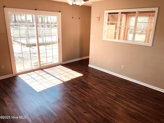 spare room with ceiling fan, wood finished floors, and baseboards