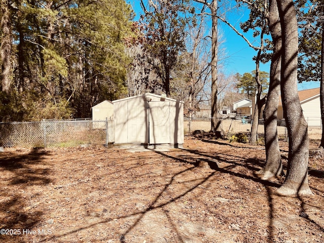 view of yard featuring an outbuilding, a fenced backyard, and a storage shed